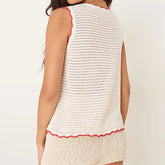 White sleeveless top with red trim on a plain background